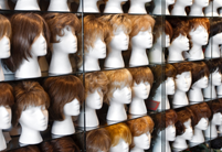 a variety of wigs on manikin heads