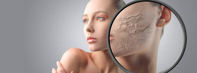 Woman with magnifying glass over her skin, exposing dried, cracked skin.